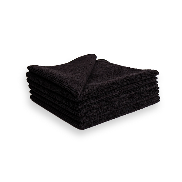 A stack of black microfibre cleaning cloths on a white background