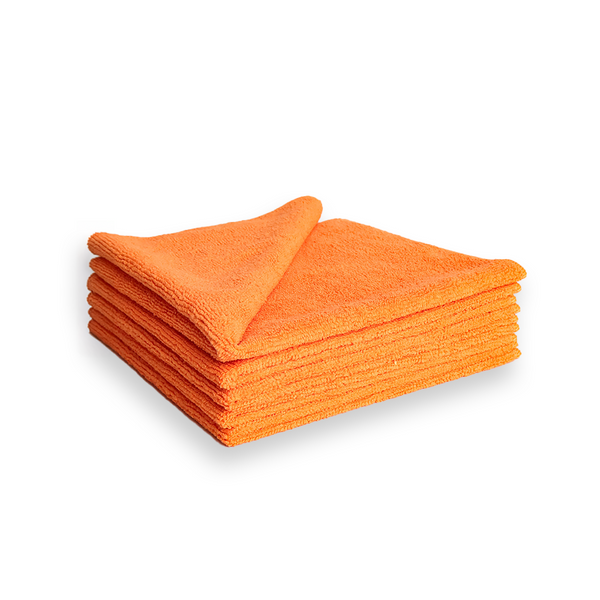 A stack of orange microfibre cleaning cloths on a white background