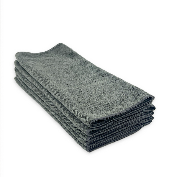 A stack of grey microfibre cloths on a white background