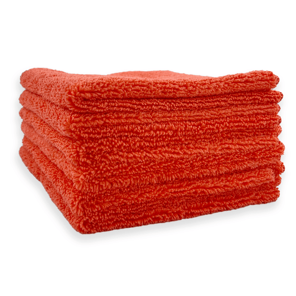 A stack of red microfibre cloths on a white background
