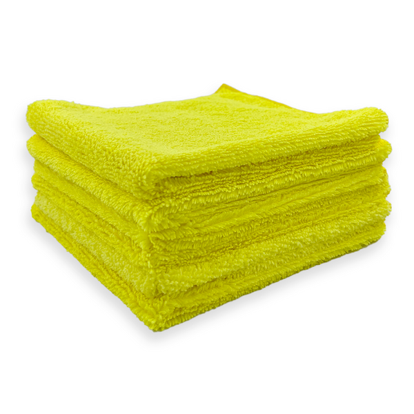A stack of yellow 310 gsm microfibre cloths on a white background