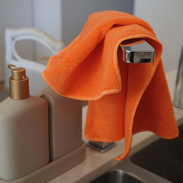 A orange Microfibre Cloth hung over a kitchen sink tap