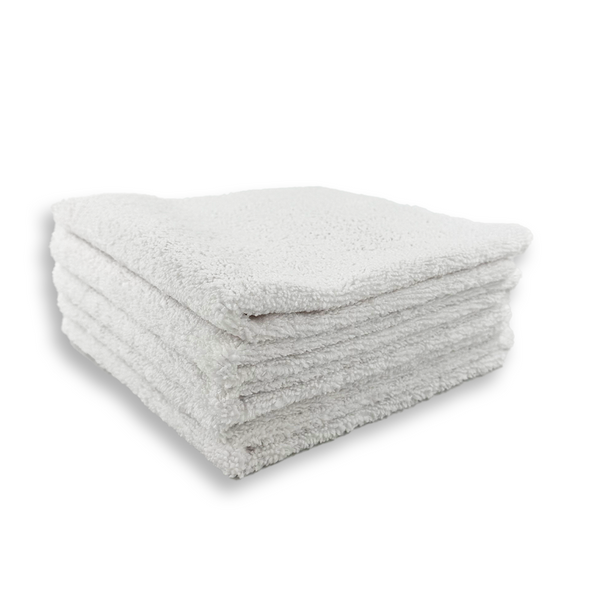 A stack of white microfibre cloths neatly folded on a white background