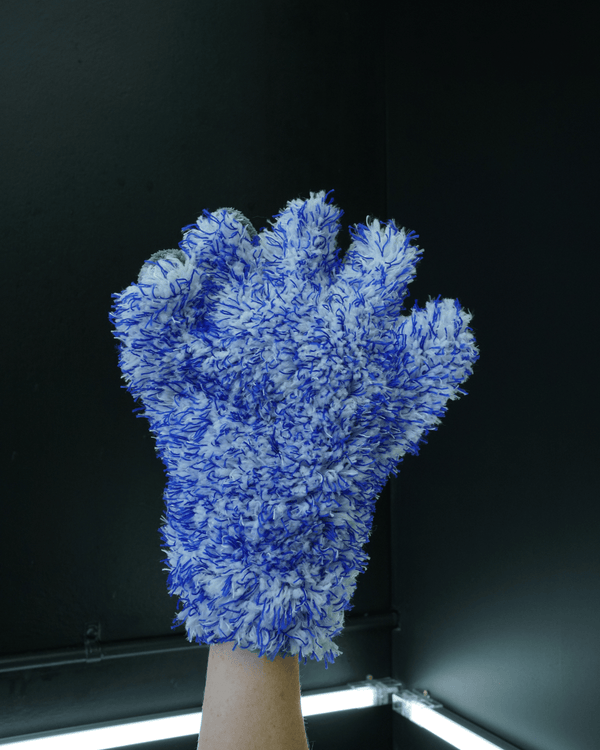 A person wearing a 5 finger microfibre wash mitt on a dark background