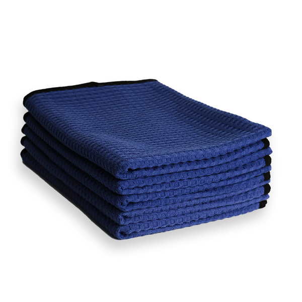 A stack of dark blue waffle weave microfibre towels on a white border