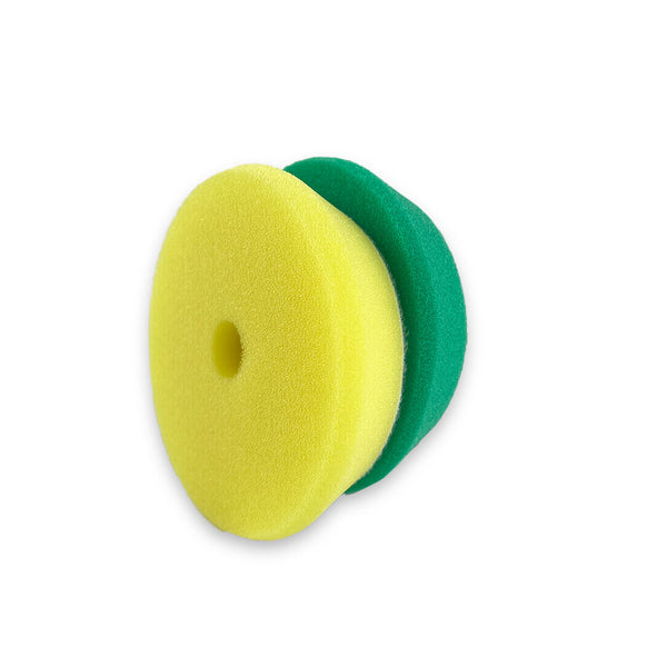 Two green and yellow beveled edge foam buffing pads with a hole in the centre for attachment.