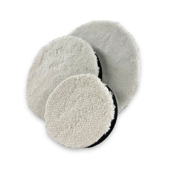 Three white coral fleece buffing pads with hook and loop backing, constructed from coral velvet microfibre, overlaid on a white surface.
