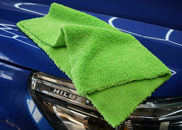 A green microfibre cloth on a blue car bonnet.