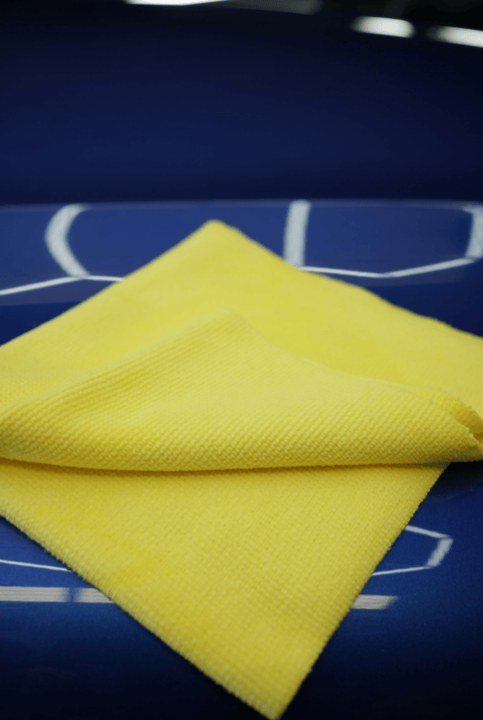 Yellow microfibre cloth on a blue surface