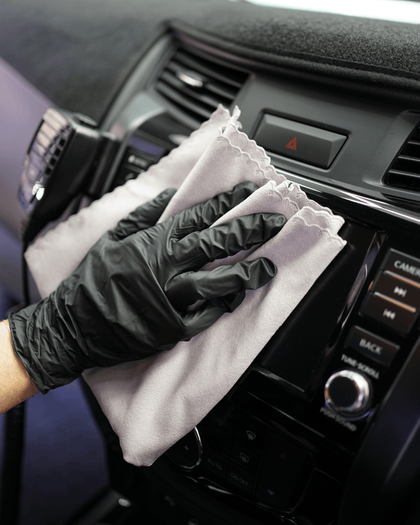 A person cleaning a car screen with a korean microfibre suede cloth