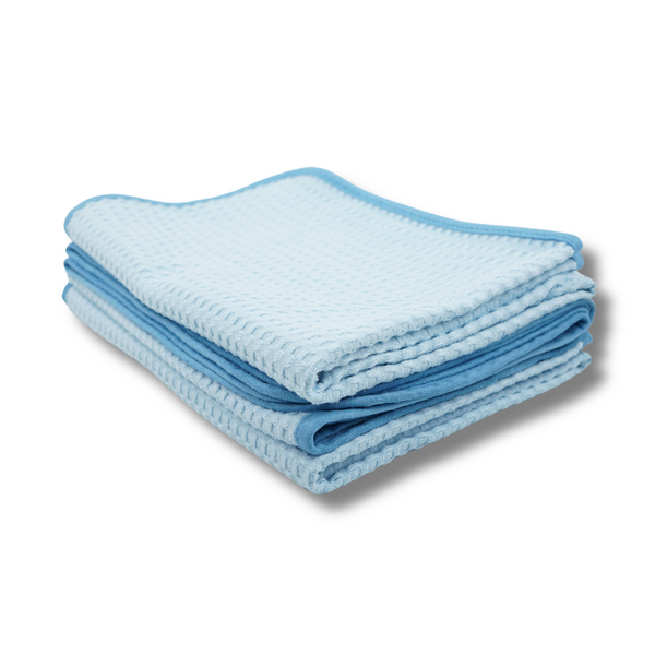Folded blue waffle towels with a dark blue border on a white background