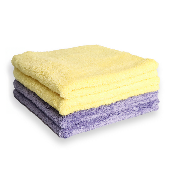 A stack of two microfiber towels, with the top towel in yellow and the bottom one in purple.