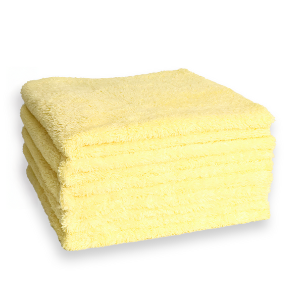 A stack of plush yellow microfibre cloths on a white background
