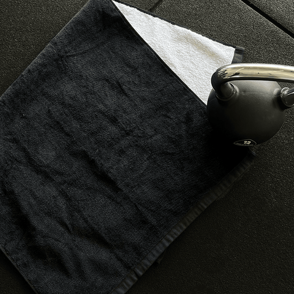 Sweat Towel Folded on Gym Floor Next to Dumbell