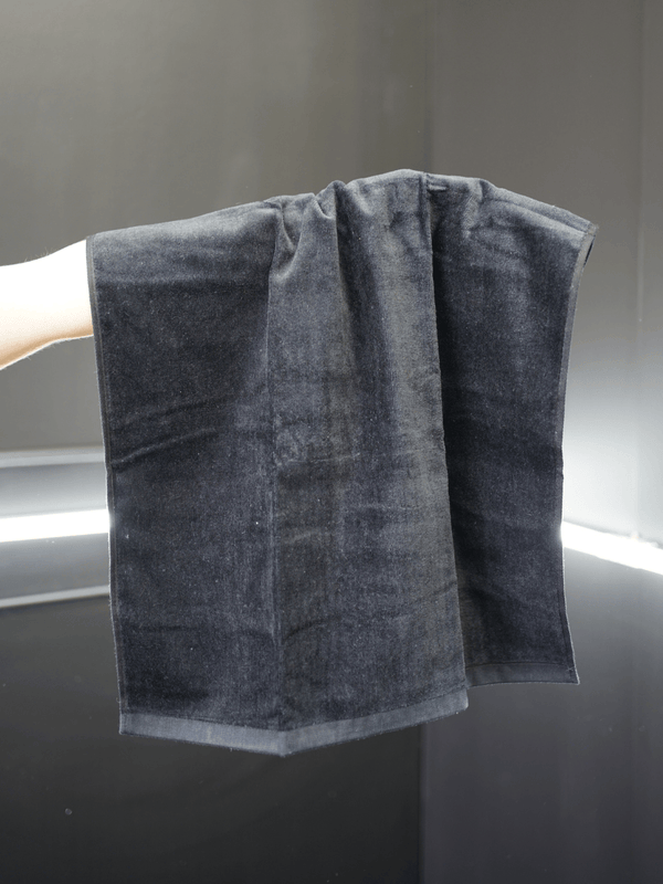 grey towel draped over a persons arm with a neutral background