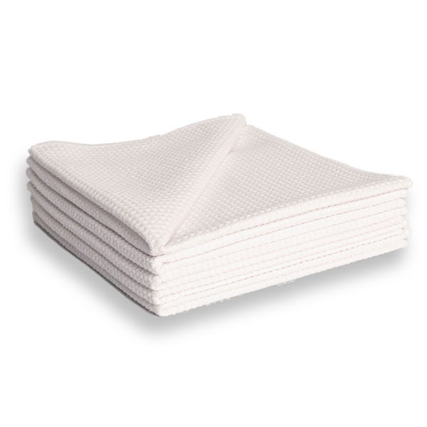 A stack of white waffle weave microfibre cloths.