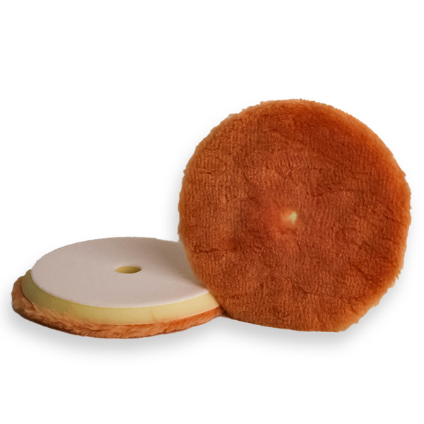 A tan wool buffing pad with a yellow backing foam, designed for car detailing and paint correction.