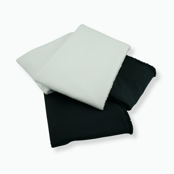Two folded microfibre, one white and one black, on a white background