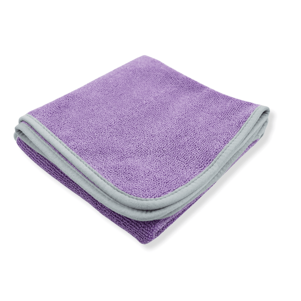 A purple microfibre drying towel neatly folded on a white background