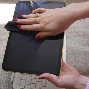 A person cleaning the screen of a ipad with a suede microfibre cloth
