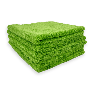 Stack of green microfibre cloths on a white background
