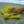 Hand with a ring holding a yellow cloth on a light grey surface