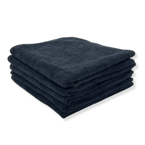 A stack of black microfibre towels on a white background