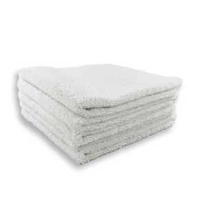 A stack of white microfibre cloths neatly folded on a white background