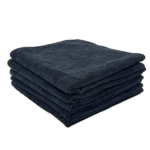 A stack of black microfibre cloths neatly folded on a white background