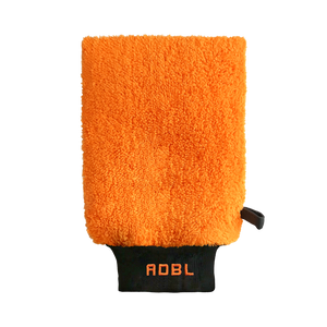 A orange clay mitt with a black band on a white background