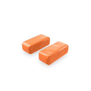 Two orange soft clay bars on a white background