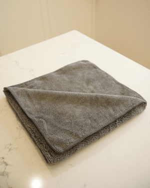 A charcoal folded microfibre cloth on a kitchen bench