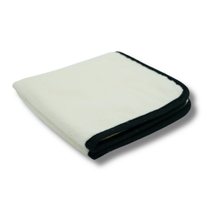 A white microfibre plush towel with black stitching on a white background
