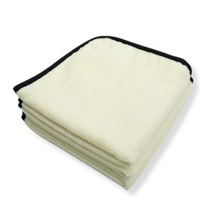 Folded stack of white towels with black trim on a white background