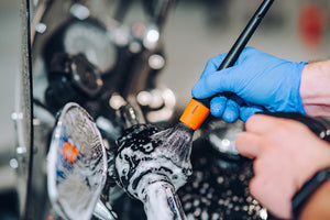 Detailer using ADBL Detail Brush to clean intricate motorcycle parts and chrome with foam soap