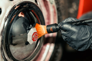 Close-up of a DETAILING BRUSH PRO Medium Soft cleaning an MG wheel centre cap