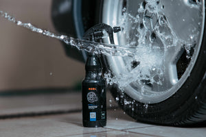 ADBL Rimtector 0.5L bottle with water beading off a polished car rim, demonstrating rim sealant hydrophobic properties.