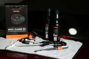 ADBL Wheel Cleaner Set contents on a microfibre towel, showing Vampire Light and Tire & Rubber Cleaner bottles with brushes and box