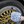 Person cleaning gold wheel with blue and white wheel mitt