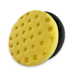 Two round foam buffing pads, one yellow and one black, with a textured surface for DA (Dual Action) polishing.