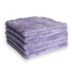 Stack of purple plush microfibre cloths on a white background