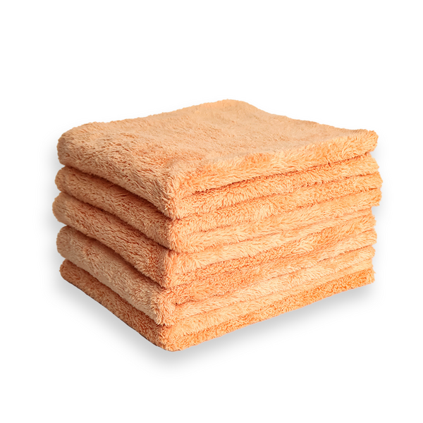 S stack of plush orange microfibre cloths on a white background