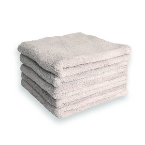 A stack of grey plush microfibre cloths on a white background
