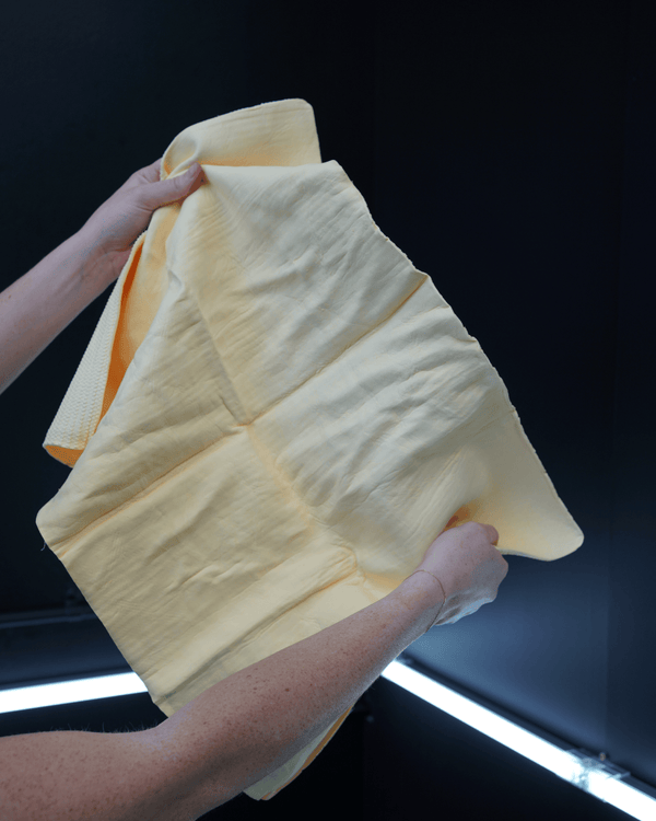 A person holding a yellow chamois