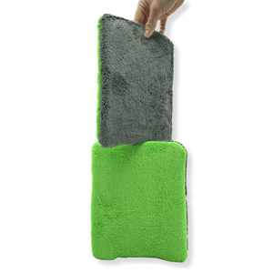 Green and grey thin wash pad held by a hand on a white background