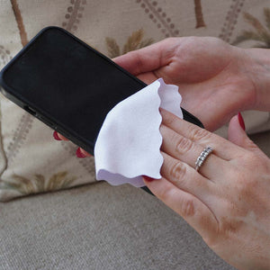 A person cleaning a phone with a small white suede cloth