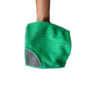 A person holding a green cloth with a scrub corner on a white background 