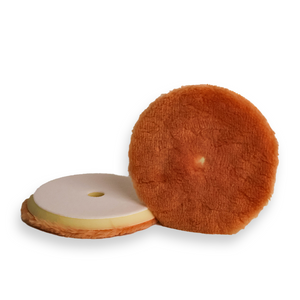 A tan wool buffing pad with a yellow backing foam, designed for car detailing and paint correction.