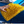 Person cleaning a blue car with a yellow microfiber cloth