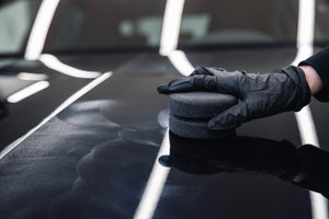 ADBL FOAMBURGER applicator applying car wax in circular motion on black car paint